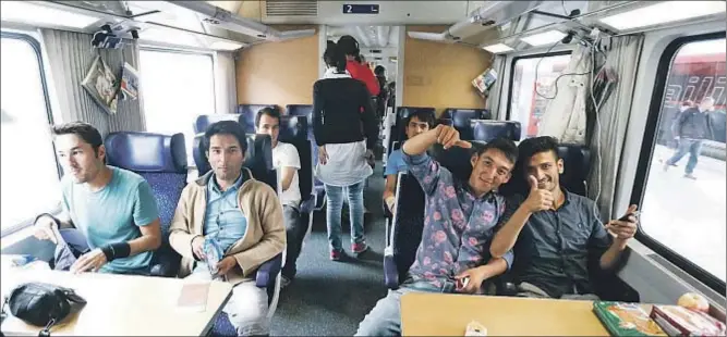 ?? DOMINIC EBENBICHLE­R / REUTERS ?? Un grupo de jóvenes inmigrante­s sirios en un tren hacia la anhelada Alemania en una estación de Viena, una vez superado el mal trago en Hungría