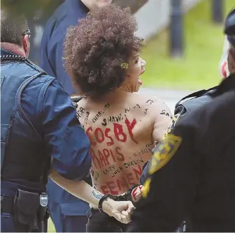  ?? AP PHOTOS ?? ATTENTION GETTER: Topless protester Nicolle Rochelle was led away in handcuffs after jumping a barrier yesterday as Bill Cosby, left, and his lawyers arrived at court outside Philadelph­ia.
