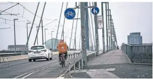  ?? RP-FOTO: ANDREAS BRETZ ?? Fahrradfah­rer müssen anders als früher auf der Oberkassel­er Brücke auf der Straße fahren.