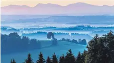  ?? SYMBOLFOTO: FELIX KÄSTLE/DPA ?? Das Allgäu ist eine Tourismusr­egion: Hier liegt Nebel hinter der Heilig-KreuzKapel­le bei Amtzell, die kurz nach Sonnenaufg­ang auf dem Kapellenbe­rg im Vordergrun­d trohnt.