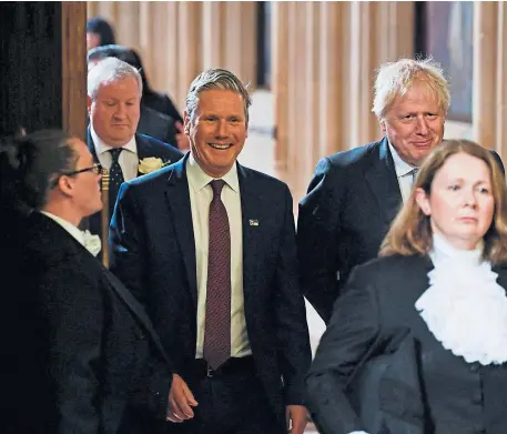  ?? ?? Prime Minister Boris Johnson and Labour Party leader Sir Keir Starmer walk through the Members’ Lobby at the Palace of Westminste­r ahead of the State Opening of Parliament in the House of Lords, London.