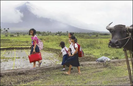  ?? EPA ?? Children walk to school amid rumblings from Mayon Volcano in Camalig, Albay on Friday.