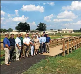  ?? DAN SOKIL — DIGITAL FIRST MEDIA ?? Upper Gwynedd and North Penn School District officials stand at the edge of one of three retention basins recently completed outside Pennbrook Middle School. From left are Upper Gwynedd Assistant Township Manager Mike Lapinski, Township Engineer Russ...