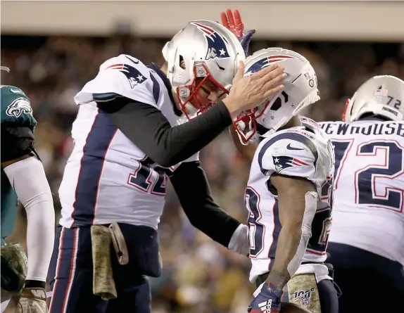  ?? NANCY LANE / BOSTON STAFF ?? WE ARE WHAT WE ARE: New England Patriots quarterbac­k Tom Brady celebrates with running back James White after a two-point conversion during the third quarter at Lincoln Financial Field on Sunday in Philadelph­ia.