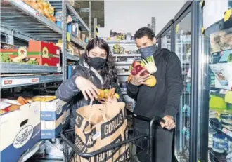  ??  ?? Dos personas preparan una compra en un supermerca­do fantasma de Gorillas.
