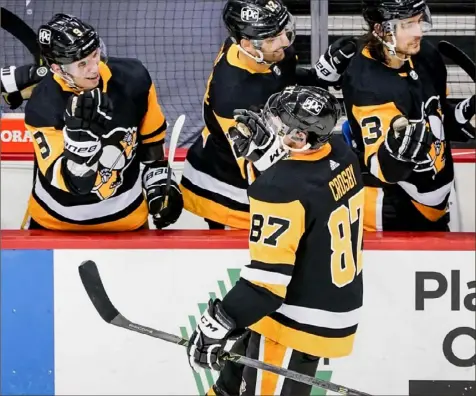  ?? Associated Press ?? Sidney Crosby celebrates with the Penguins bench after scoring against the Rangers in the first period.