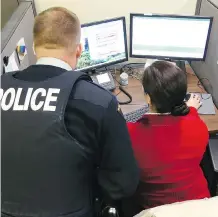  ?? JIM WELLS ?? RCMP Const. Lindon Green works with a PROS data centre civilian staff member on Tuesday.