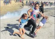  ?? REUTERS ?? Maria Lila Meza Castro runs from tear gas with her twin daughters Saira Nalleli Mejia Meza and Cheili Nalleli Mejia Meza.