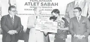  ?? ?? SERAH: Hajiji menyampaik­an replika cek insentif kemenangan kepada pemenang pingat emas sukan berbasikal, Natahsya Soon pada Majlis Meraikan Pencapaian Altet Sabah Sempena Temasya Sukan SEA ke-31, Hanoi 2021 di Menara Kinabalu di sini.