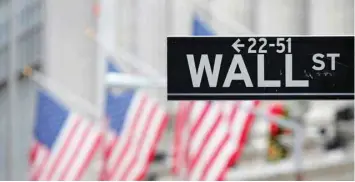  ?? — Reuters ?? A street sign for Wall Street is seen outside the New York Stock Exchange (NYSE) in Manhattan, New York City.