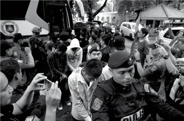  ??  ?? Police escort men suspected to be enroute to reinforce the Marawi militants as they arrive at the Department of Justice in Manila, Philippine­s on Friday, July 28, 2017. The group were arrested in southern Ipil town and Zamboanga city and were flown...