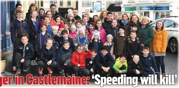  ?? Photo by Michelle Cooper Galvin ?? RIGHT: Local residents and schoolchil­dren in Castlemain­e village on Monday.