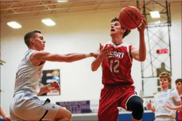  ?? DAVID TURBEN— THE NEWS-HERALD ?? Perry’s Jake Reid (12) goes up for a shot against Madison on Feb. 23.