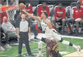  ?? STACY REVERE — GETTY IMAGES ?? Giannis Antetokoun­mpo of the Bucks goes over the top of Hawks defender Clint Capela during Game 2 of the Eastern Conference Finals. The Bucks won in a rout to even the series