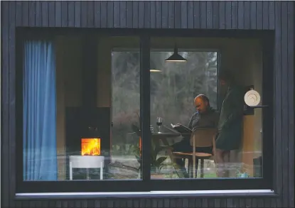  ??  ?? Guy De Deyn and Devos enjoy a wood fire as they read a book together in a Slow Cabin in Elewijt, Belgium.