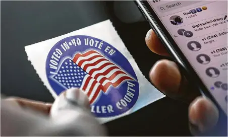  ?? Jon Shapley / Staff photograph­er ?? Prairie View A&amp;M University sophomore Drew William looks at the sticker he received after voting early off campus Wednesday. Waller County will extend hours for the second week of early voting at the on-campus polling site after a lawsuit was filed.