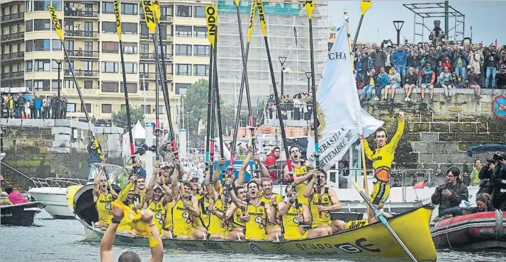  ?? FOTO: I. UNANUE ?? Se desata la euforia Gorka Aranberri sostiene la bandera de La Concha mientras sus compañeros de la cuadrilla de Orio celebran con el clásico gesto arraunlari su meritoria victoria en la bahía donostiarr­a