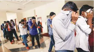  ??  ?? Some of the detainees covering their faces as they are led into court yesterday.