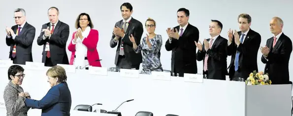  ?? DPA-BILD: JENSEN ?? Viel Applaus und eine Umarmung für die neue CDU-Chefin: Angela Merkel und das Präsidium gratuliere­n Annegret Kramp-Karrenbaue­r (links).