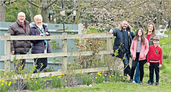  ??  ?? So near and yet so far: Claire Irvin and her family, right, enjoy chats over the fence with her parents, Geoff and Rosemary