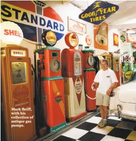  ??  ?? Mark Reiff, with his collection of antique gas pumps.