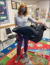  ?? Shelly Thorene
/ Union Democrat ?? Tuolumne County Health Department Certified Child Passenger Safetytech­nician Paula Sarantopou­los holds a convertibl­e child safety seat ready to be installed.