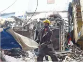  ?? — RAJESH JADHAV ?? A rescue worker clears the rubble after a one-storey residentia­l structure collapsed at Shivaji Nagar in Govandi, Mumbai, on Friday.