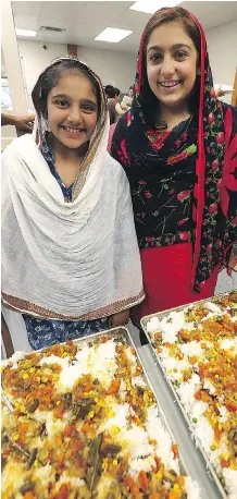  ?? KEVIN KING ?? Sisters Jasmyn, 11, left, and Simryn Singh, 15, serve traditiona­l Sikh and Indigenous dishes to people in need in Winnipeg.