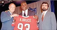  ?? AP-Ron Frehm, File ?? Aundray Bruce (center) holds up his future jersey with help from NFL commission­er Pete Rozelle (left) and Rankin Smith Jr., president of the Atlanta Falcons. Bruce was heralded as the next Lawrence Taylor when he arrived from Auburn in 1988, but he’s now remembered as one of the most notorious busts in NFL history.