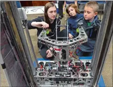  ?? DANA JENSEN THE DAY ?? Interning Aluminum Falcons mentor Deidra Hall, left, tells Liam Greason, 12, and Dalton Vyr, 6, both of Groton, about the robotics team’s robot during the Encounteri­ng Robots with Aluminum Falcons Robotics & 4-H event Saturday at the Groton Public Library.