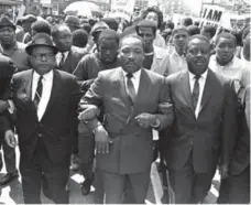 ?? THE ASSOCIATED PRESS ?? Rev. Ralph Abernathy, right, and Bishop Julian Smith, left, flank Dr. Martin Luther King, Jr., during a civil rights march in Memphis, Tenn., in 1968.