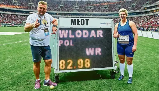  ??  ?? She ain’t heavy, she’s my knockout: Poland’s Olympic and world hammer throw champion Anita Wlodarczyk (right) posing with her coach Krzysztof Kliszewski in front of a board showing her new world record at the Kamila skolimowsk­a athletics meet in...
