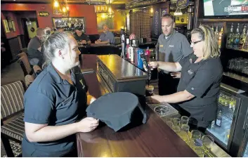  ?? JULIE JOCSAK/STANDARD STAFF ?? Doc Magilligan’s Restaurant & Irish Pub day supervisor Colleen Cade, left, beverage manager Kenneth Ahern and bartender Terri Angell. The Lundy’s Lane establishm­ent was named one of the top 10 Irish pubs in North America by the Irish Pubs Global...