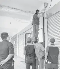  ??  ?? BERJAYA DIKESAN: Juruteknik SESCO membuang torehan terus pada kabel SESCO sambil disaksikan oleh inspektor daripada EIU dan polis.