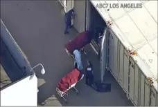  ?? ABC7 LOS ANGELES VIA AP ?? This file photo from video provided by ABC7 Los Angeles shows workers putting bodies into a refrigerat­ed trailer at the offices of the Los Angeles County Coroner in Los Angeles. More than 500 people are dying each day in California because of the coronaviru­s.