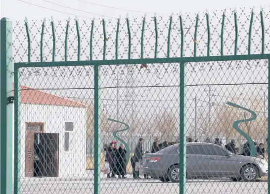  ?? NG HAN GUAN/AP ?? People line up at the Artux City Vocational Skills Education Training Service Center at the Kunshan Industrial Park in Artux in western China’s Xinjiang region in 2018. Internatio­nal lawyers and activists are prodding Olympic sponsors to acknowledg­e China’s widely reported human-rights abuses.