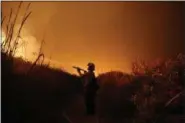  ?? JAE C. HONG — THE ASSOCIATED PRESS FILE ?? Firefighte­r Ryan Spencer battles a wildfire as it burns along a hillside toward homes in La Conchita With three strong hurricanes, wildfires, hail, flooding, tornadoes and drought, supersized weather disasters tallied a record high bill for America...