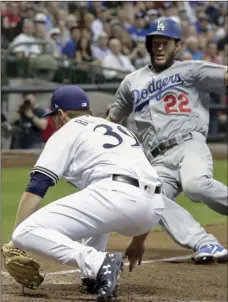  ??  ?? Milwaukee Brewers’ Corbin Burnes tags out Los Angeles Dodgers’ Clayton Kershaw during the fifth inning of a baseball game on Saturday, in Milwaukee. Kershaw tried to score from third on a pitch that got passed catcher Erik Kratz. AP PHOTO/MORRY GASH