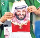  ?? Foto: APA / AFP / Fayez Nureldine ?? Ein saudischer Fußballfan zeigt König (li.) und Kronprinz her.