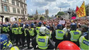  ?? (Will Russell/Reuters) ?? POLICE OFFICERS stand guard during an anti-lockdown demonstrat­ion in London’s Parliament Square on Monday.