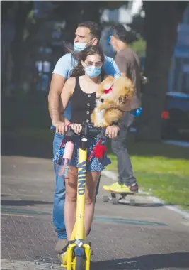  ?? (Miriam Alster/Flash90) ?? A MASKED couple scoots along Tel Aviv’s Rothschild Boulevard on July 8.
