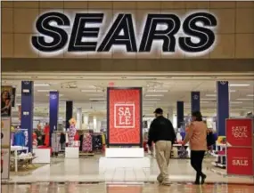  ?? AP PHOTO/GENE J. PUSKAR ?? Shoppers walk into a Sears store in Pittsburgh. Sears said that there is “substantia­l doubt” that it will be able to remain in business. The company, which runs Kmart and its namesake stores, has struggled for years with weak sales.