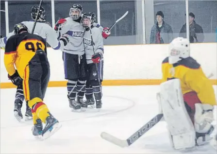  ?? DAVID BEBEE WATERLOO REGION RECORD ?? Huron Heights players, from left, Matthew Ortleib, Jon Richards and Colter Roughly celebrate a goal against KCI on Monday. Huskies won, 7-3.