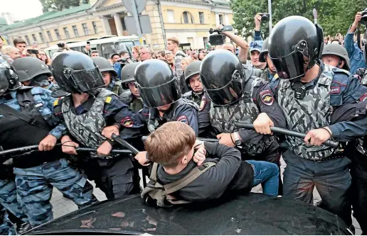  ?? AP ?? Russian police officers push a teenager during a rally protesting retirement age hikes in St Petersburg.