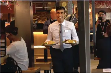  ??  ?? SERVING THE NATION: Rishi reliving a teenage job waitering to promote his meal deal last week