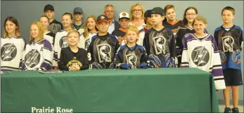  ??  ?? Willie Desjardins and PRSD deputy chair Cathy Hogg (back row, centre) are joined by a group of young hockey players for a photo.