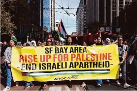  ?? Yalonda M. James/The Chronicle ?? A large crowd marches Saturday during the “All Out for Gaza” rally, which began at Harry Bridges Plaza near the Embarcader­o in San Francisco.