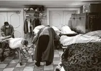  ?? Godofredo A. Vásquez / Staff file photo ?? Mortician Jeff Sonka, center, and his assistant Manuel Santos rearrange the bodies at Compean Funeral Home in August.