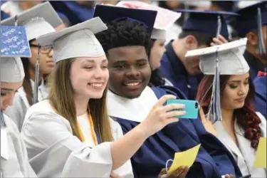  ?? ERIC BONZAR — THE MORNING JOURNAL ?? Senior Class Representa­tive Emily Shelton and National Honor Society President Sly Worthy take a selfie during the Lorain High School Class of 2017 commenceme­nt ceremony, June 6.