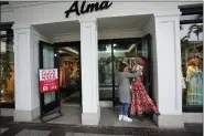  ?? ?? An employee sets up a display, outside a clothing stores advertisin­g sales ahead of Black Friday and the Thanksgivi­ng holiday, Monday, in Miami.